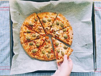 Cropped hand having pizza