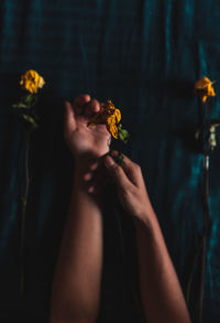 Midsection of woman holding yellow flower