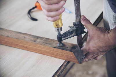 Midsection of man working on wood