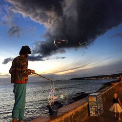 Man on beach against sky at night