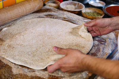 Close-up of man preparing dough in kitchen
