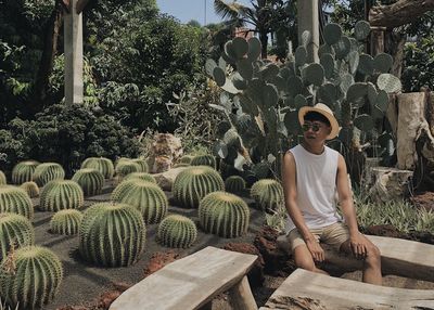 Portrait of young man standing in greenhouse