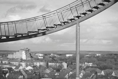 Footbridge and old town against sky