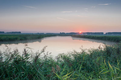 Scenic view of lake against sky during sunset