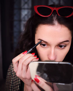 Portrait of young woman holding eyeglasses
