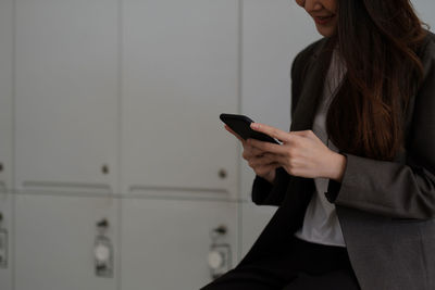 Midsection of woman using mobile phone