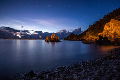 Scenic view of lake against sky at night