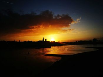 Silhouette buildings against sky during sunset