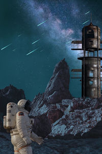 Digital composite image of buildings and rocks at night