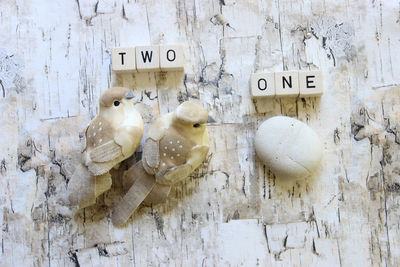 Close-up of text made from dice by bird figurine and stone on wooden table