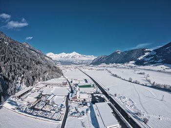 Scenic view of snow covered mountains against blue sky