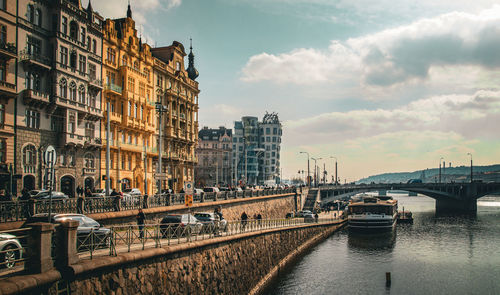 Bridge over river in city against sky