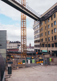 Construction site by buildings against sky