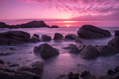 Scenic view of sea against dramatic sky during sunset