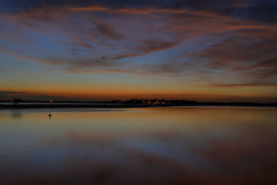 Scenic view of lake against sky at sunset