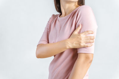 Midsection of woman standing against white background