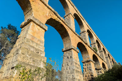 Arch bridge against clear blue sky