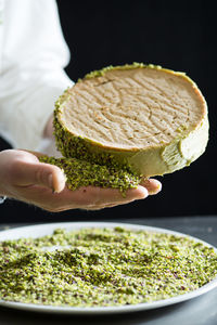 Close-up of chef's hand holding cake