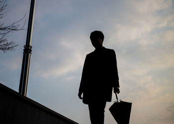 Low angle view of man standing against sky