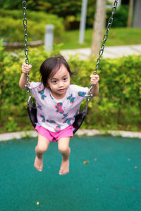 Cute girl on swing at playground
