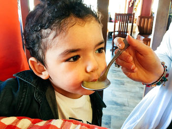 Cropped hands of woman feeding baby boy at restaurant