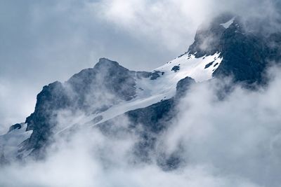 Low angle view of snowcapped mountains against sky