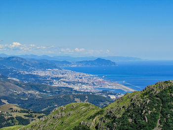 Scenic view of sea and mountains against blue sky