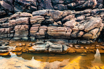 Rocky sea beach with crashing waves at morning from flat angle