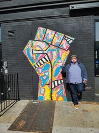 Full length of man standing against multi colored wall