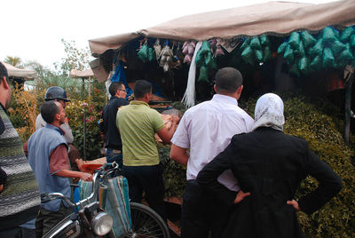 Rear view of people standing on road