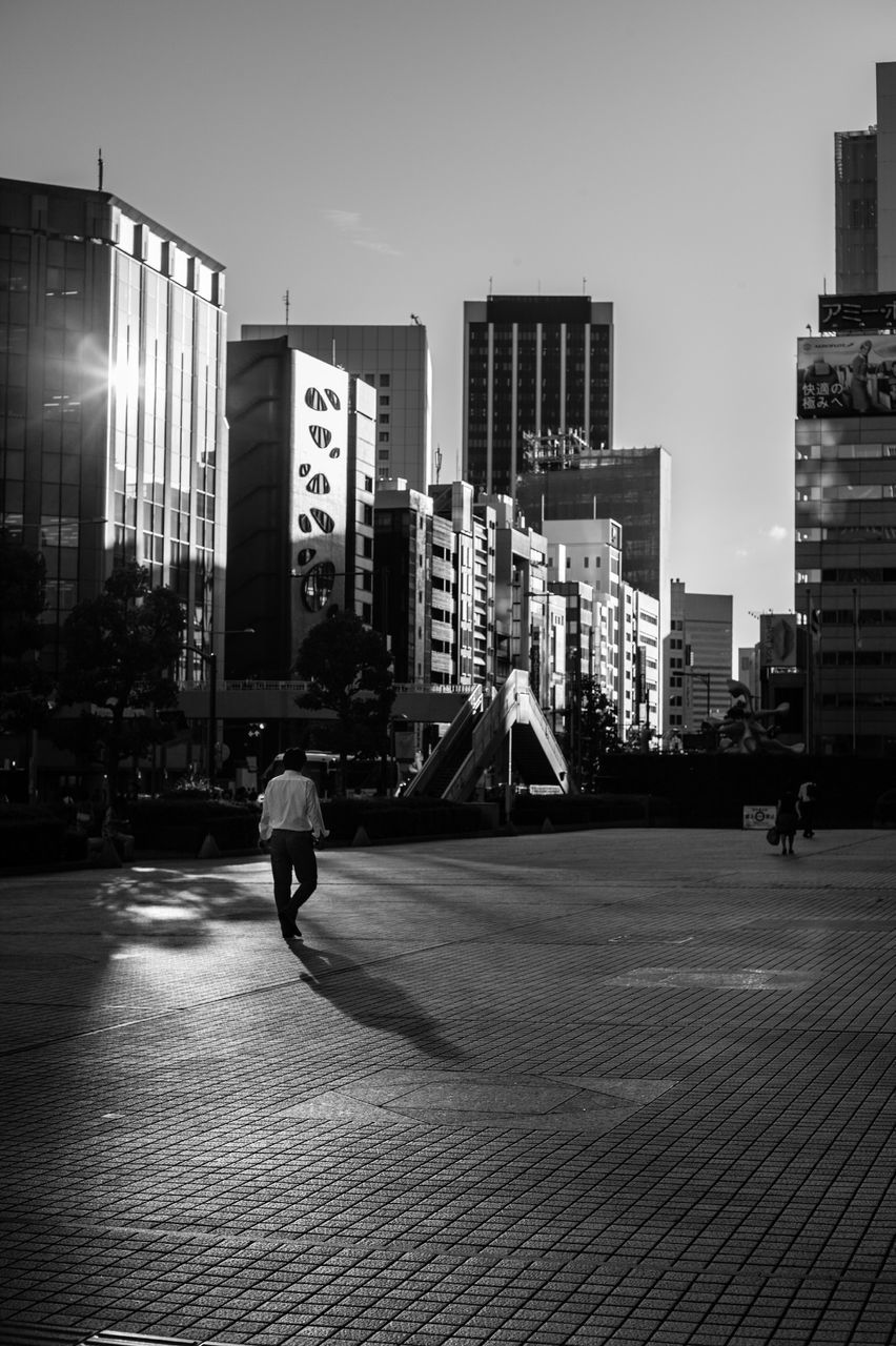 building exterior, architecture, built structure, city, street, transportation, city life, land vehicle, men, mode of transport, road, city street, full length, car, walking, building, bicycle, lifestyles