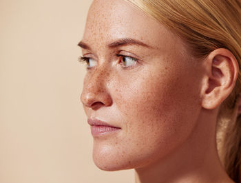 Close-up of young woman against pink background