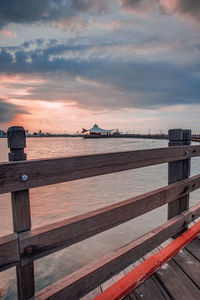 Pier over sea against sky during sunset