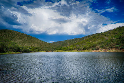 Scenic view of lake by mountains against sky