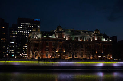 Illuminated city against sky at night