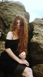 Beautiful young woman standing on rock