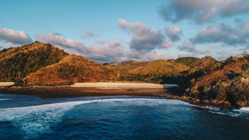 Scenic view of river by mountains against sky