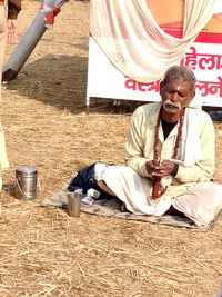 Full length of man sitting outdoors