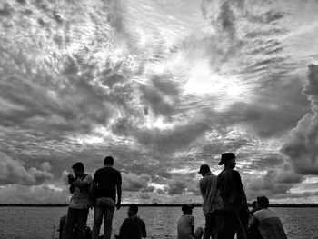 Rear view of people standing on beach