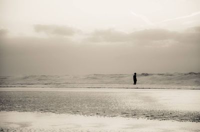 Man standing on beach against sky