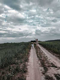 Road amidst field against sky