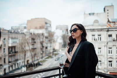 Young woman standing against buildings in city