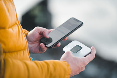 Cropped hand of man using mobile phone