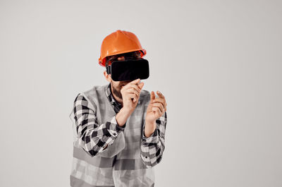 Man photographing with mobile phone against white background