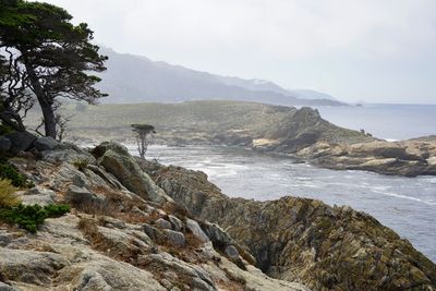 Scenic view of sea and mountains against sky