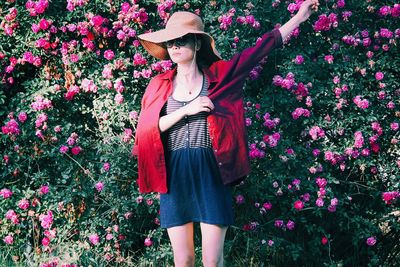 Midsection of woman standing by flowering plants