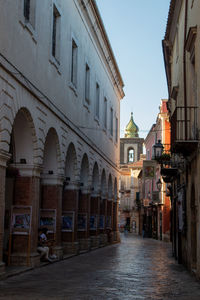 Alley amidst buildings against sky in a historical village with the sight of a church 