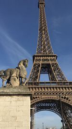 Low angle view statue against eiffel tower and sky