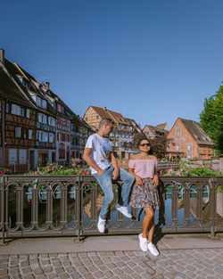 Women standing by built structure against clear sky