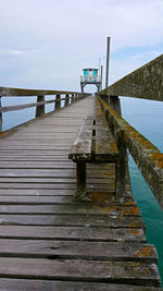 View of jetty leading to calm sea